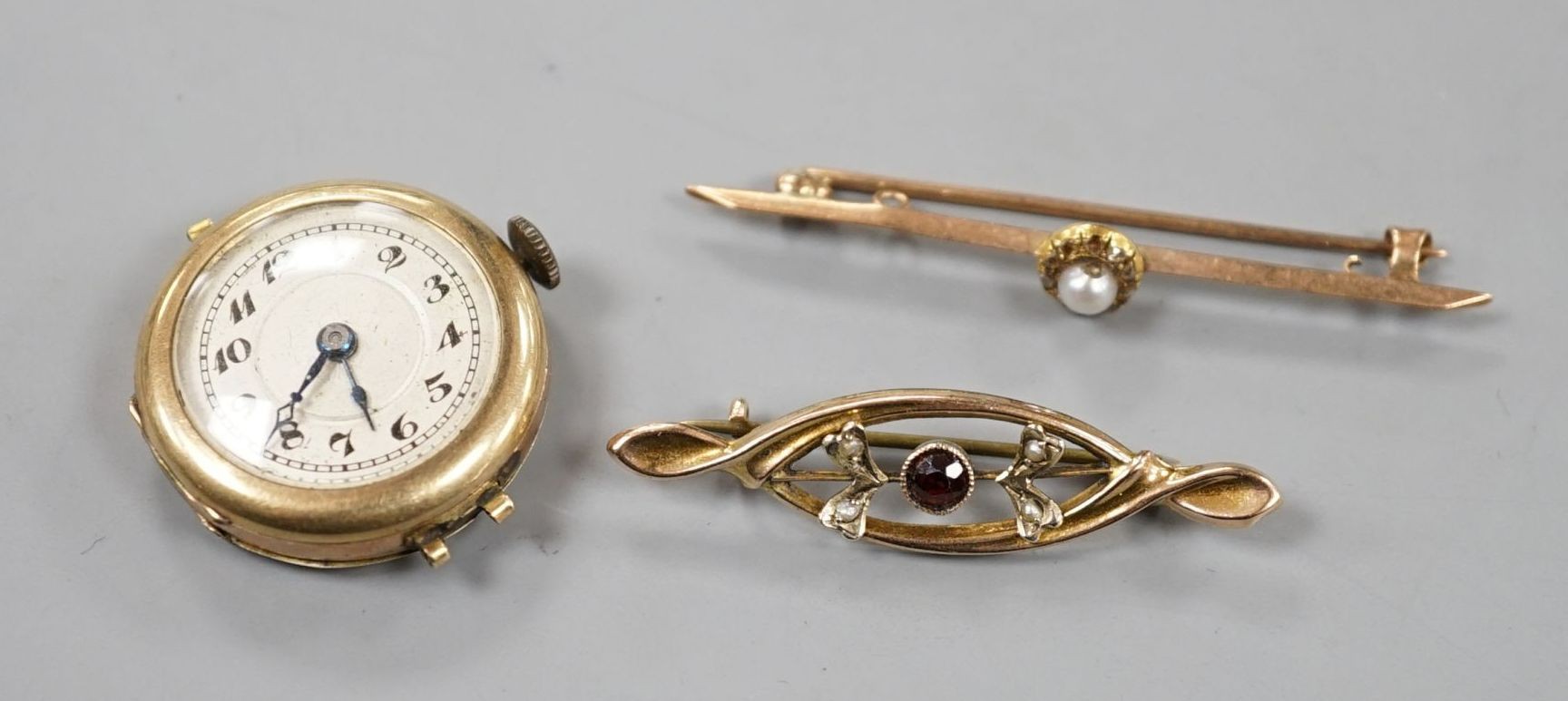 Two early 20th century 9ct and gem set bar brooches and a lady's 9ct manual wind wrist watch, no strap